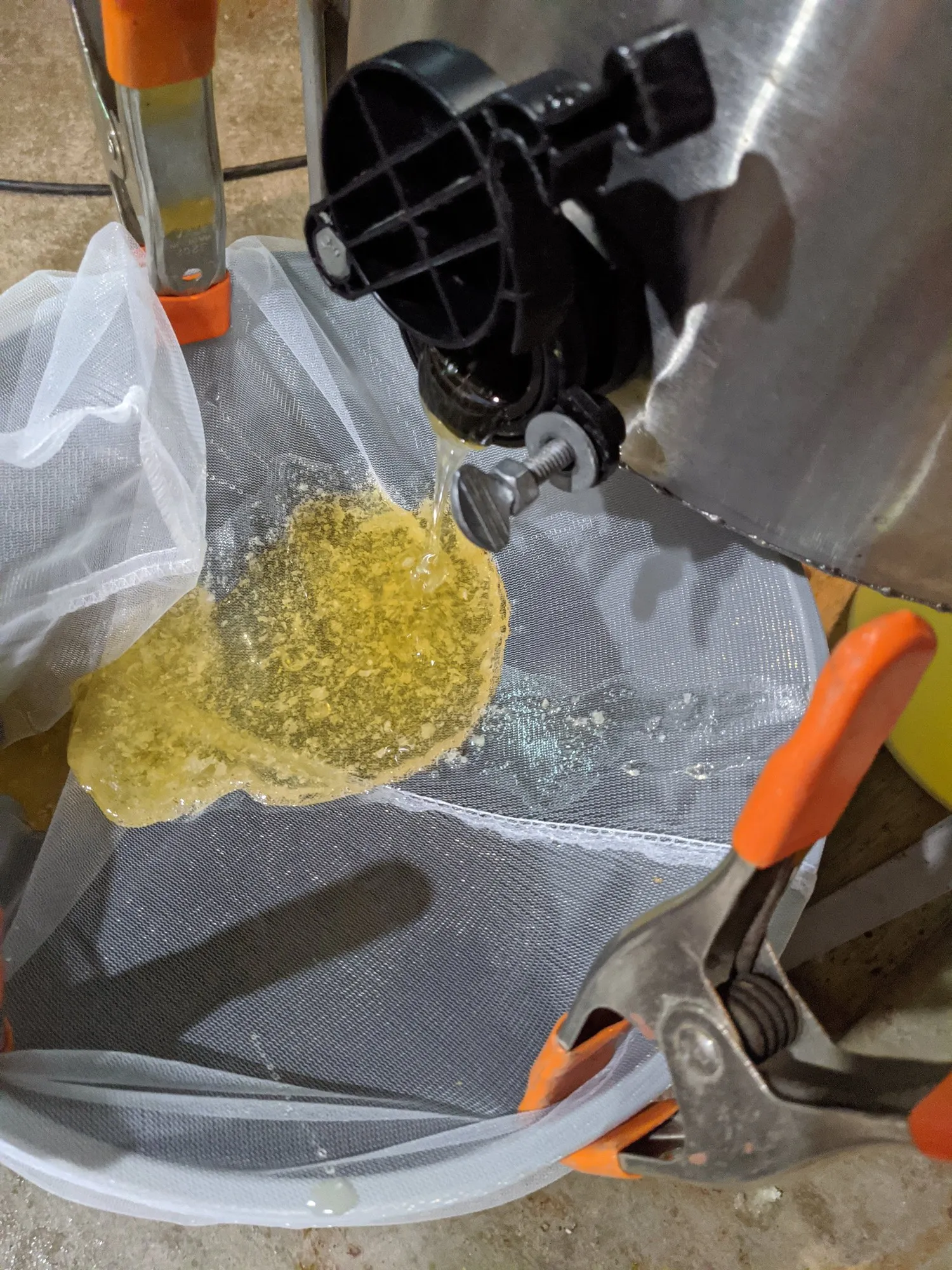 Honey and wax cappings passing through a straining bag