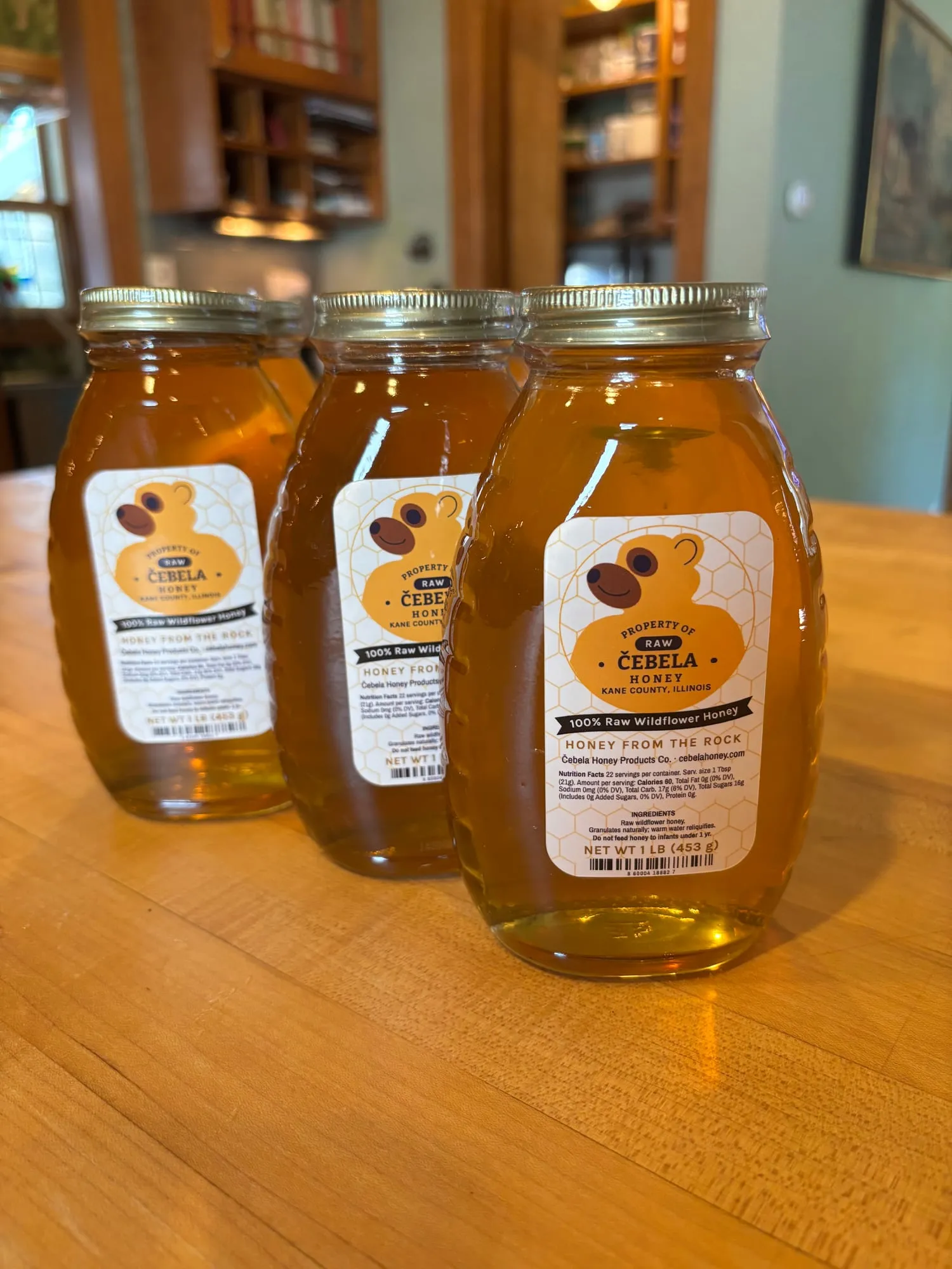 Three one-pound jars of Čebela raw wildflower honey