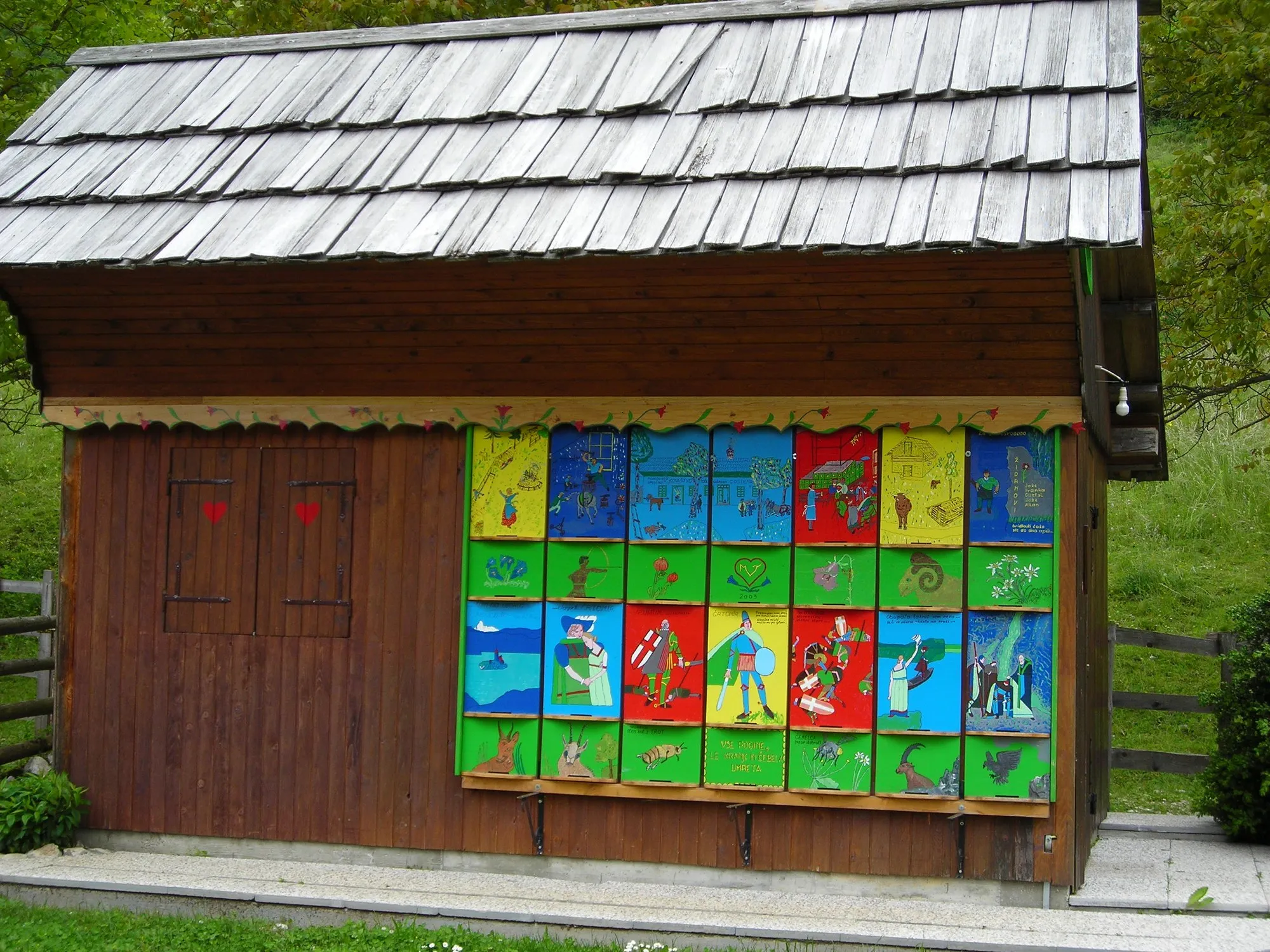 A bee house with a full row of painted hive fronts